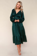 woman wearing a dark green long sleeve tiered maxi dress with a v-neckline and ruffled details