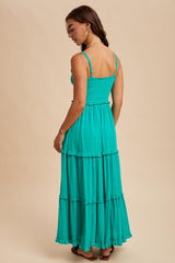 woman wearing a teal tiered maxi dress with thin straps and a smocked bodice, viewed from the back