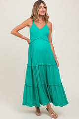 woman wearing a green tiered maternity dress with adjustable spaghetti straps and a visible baby bump