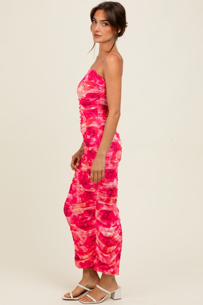 woman wearing a pink and red printed ruched spaghetti strap jumpsuit and white sandals