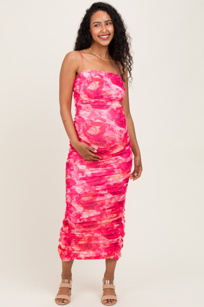woman wearing a pink tie-dye maternity dress with ruching and a visible baby bump
