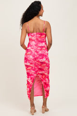 woman wearing a pink tie-dye maternity dress with ruching and a back slit