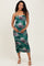 woman wearing a green floral ruched maternity dress and holding her baby bump