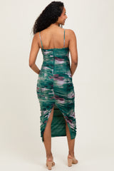 woman wearing a green and purple tie-dye maternity dress with ruching and a side slit, showing her baby bump from the back