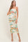 woman wearing a multicolor tie-dye maternity dress with ruching and spaghetti straps, holding her baby bump