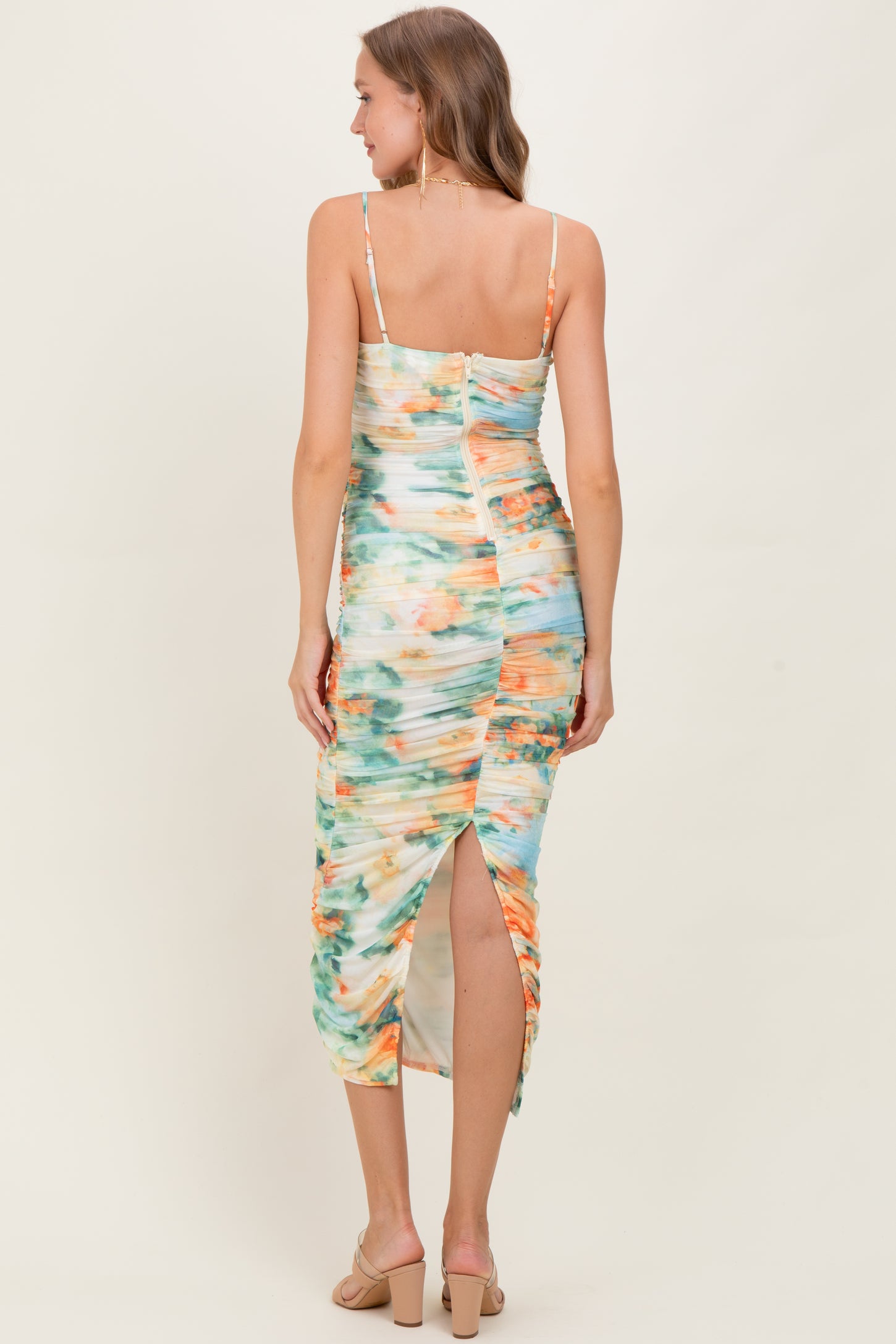 woman wearing a colorful tie-dye maternity dress with a back slit and adjustable straps