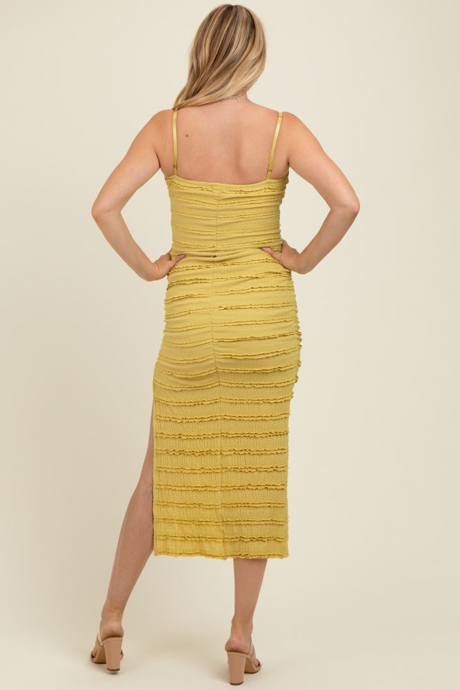 woman wearing a mustard yellow maternity dress with a fitted design and side slit, showing a baby bump