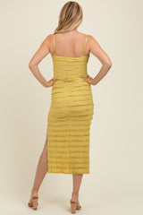 woman wearing a mustard yellow maternity dress with a fitted design and side slit, showing a baby bump