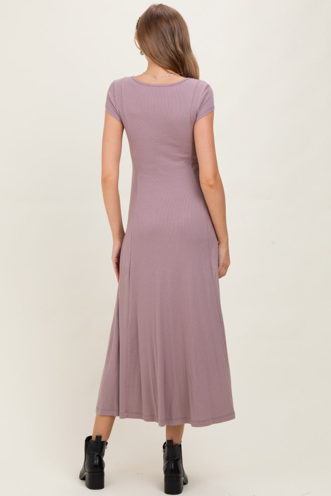 woman wearing a lavender short sleeve maternity dress with a flowing skirt, showing a fitted silhouette from the back