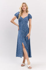 woman wearing a blue polka dot midi dress with puff sleeves and a side slit