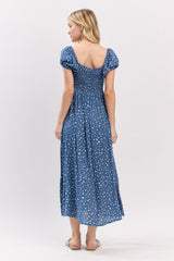woman wearing a blue polka dot maxi dress with short puff sleeves and a smocked bodice