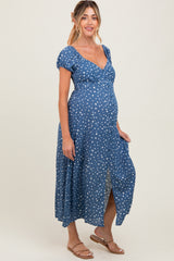 woman wearing a blue polka dot maternity maxi dress with a v-neck and short puff sleeves, showcasing her baby bump