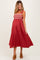 woman wearing a red maternity maxi dress with embroidered details and a visible baby bump