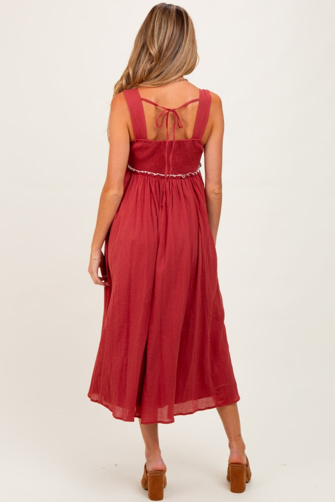 woman wearing a red maternity maxi dress with a smocked back and adjustable straps, showing a stylish and comfortable fit