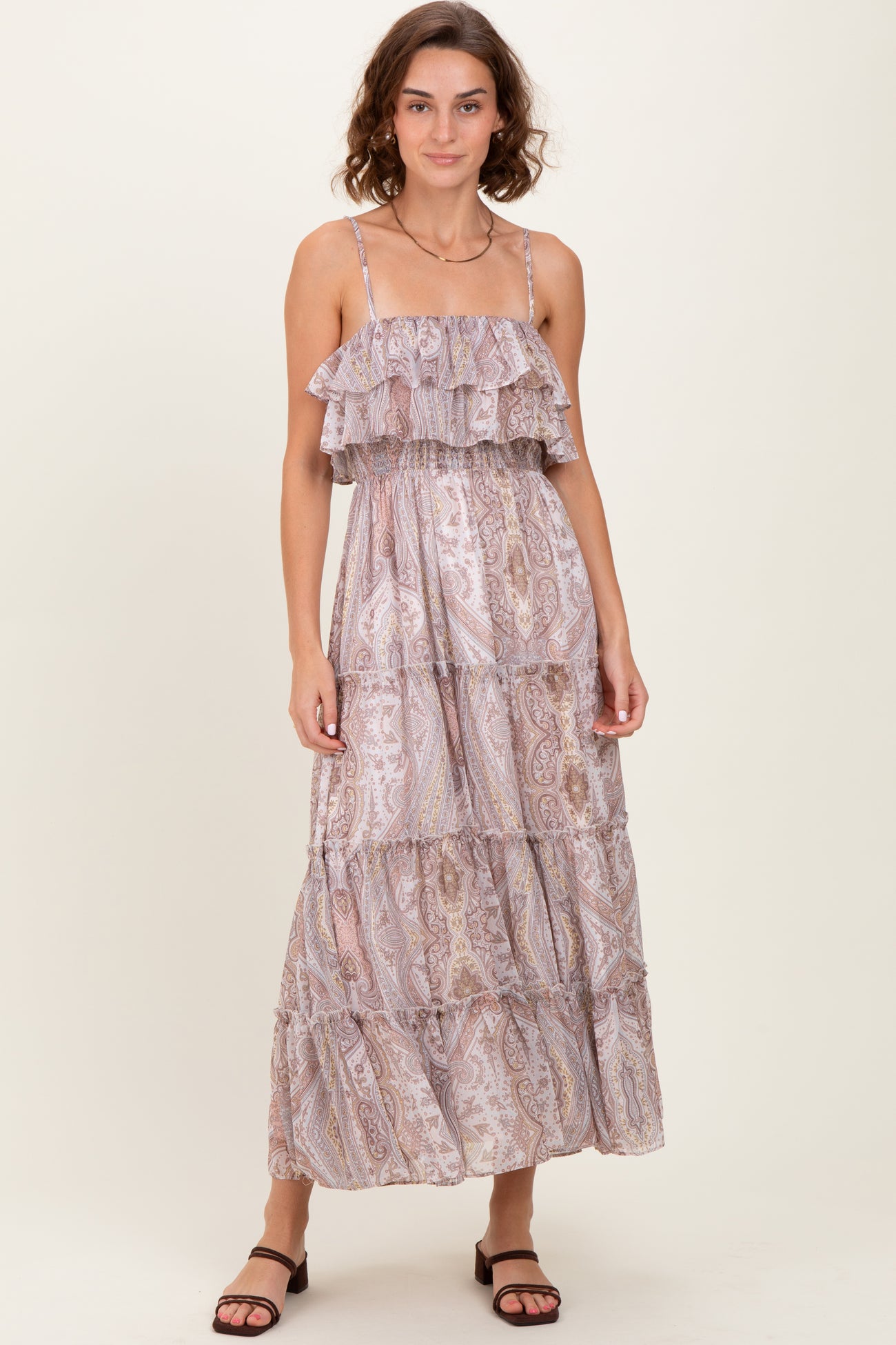 woman wearing a light purple tiered maxi dress with ruffled straps and a paisley pattern