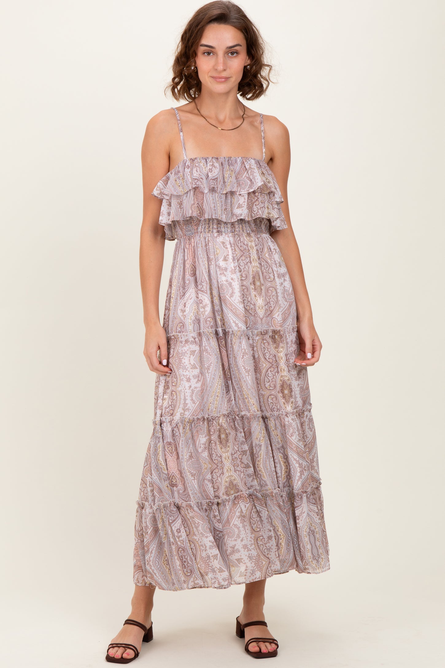 woman wearing a light purple tiered maxi dress with ruffled straps and a paisley pattern