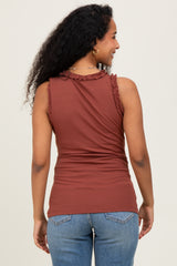 woman wearing a rust-colored maternity tank top with ruffle details, showing her baby bump from the back