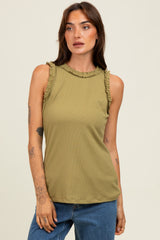 woman wearing an olive green sleeveless top with ruffle detailing along the neckline and styled with blue jeans