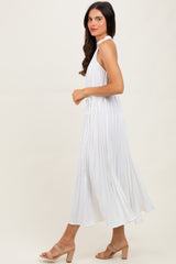 woman wearing a white sleeveless maxi dress with pleated details, styled with beige block-heel sandals