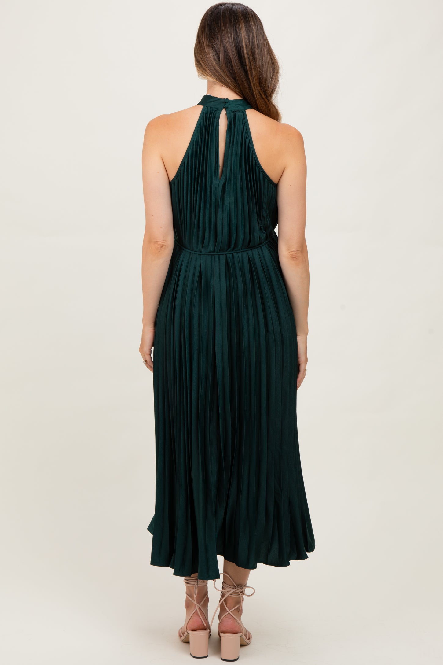 maternity wear dark green pleated maxi dress with a halter neck and cutout back, model seen from the back