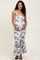 woman wearing a black and white floral print maternity dress with a fitted silhouette and flared hem, holding her baby bump