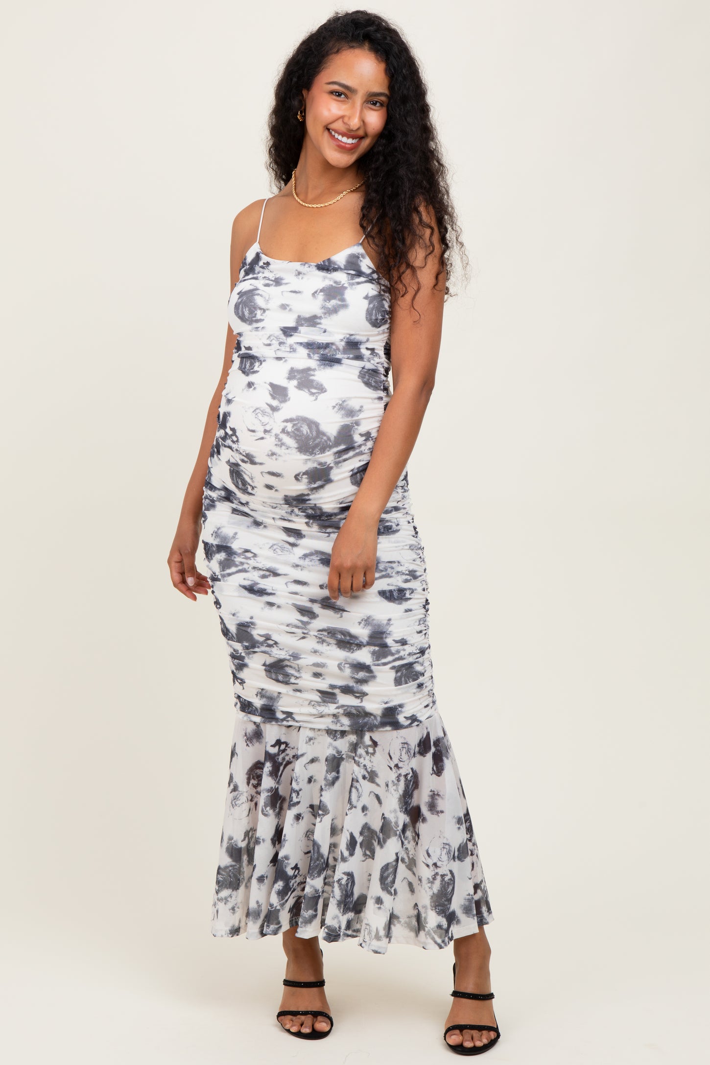 woman wearing a white and gray tie-dye maternity dress with a flared hem and a visible baby bump