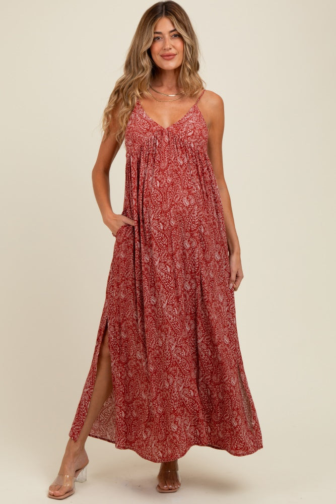 woman wearing a red paisley print maternity maxi dress with pockets and side slits