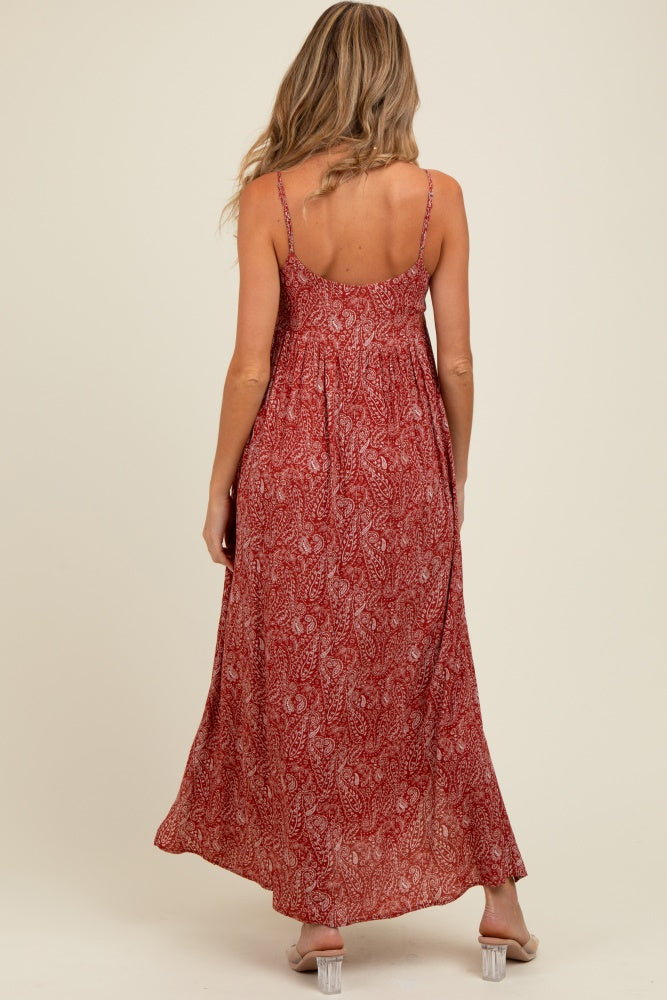 woman wearing a red printed maternity maxi dress with adjustable straps, showing a baby bump from the back