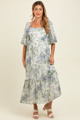 woman wearing a floral maternity maxi dress with puffed sleeves and a square neckline, showcasing her baby bump