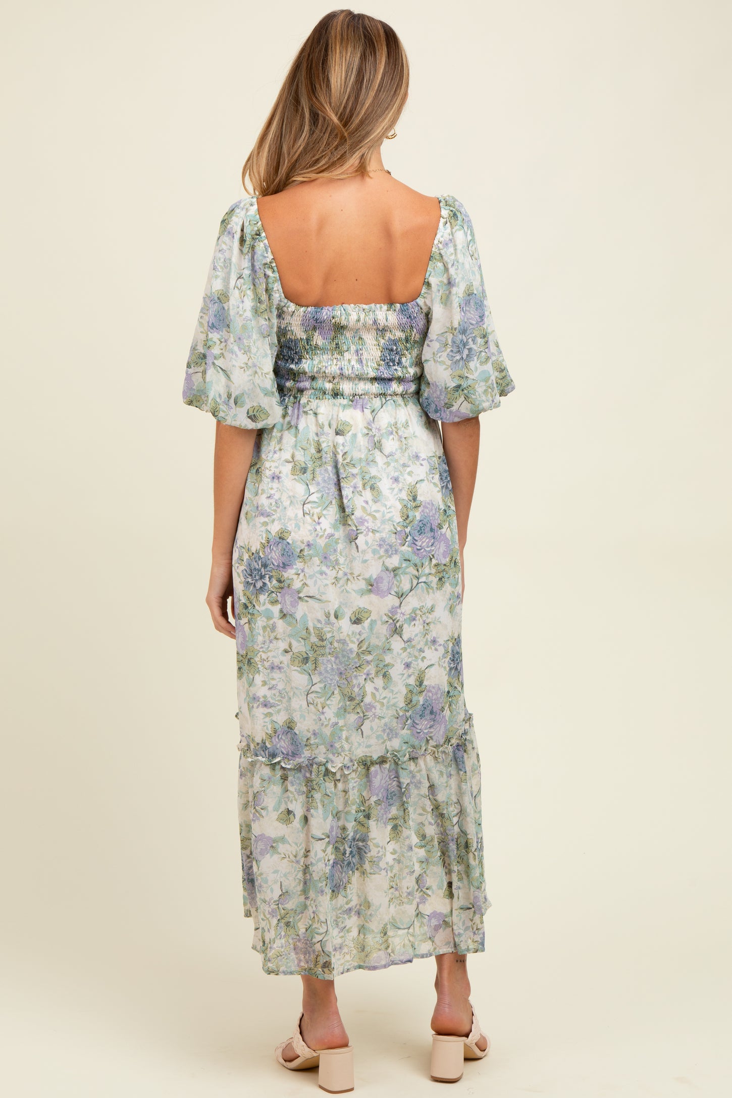woman wearing a floral maternity maxi dress with puff sleeves and a smocked back, showcasing a beautiful print