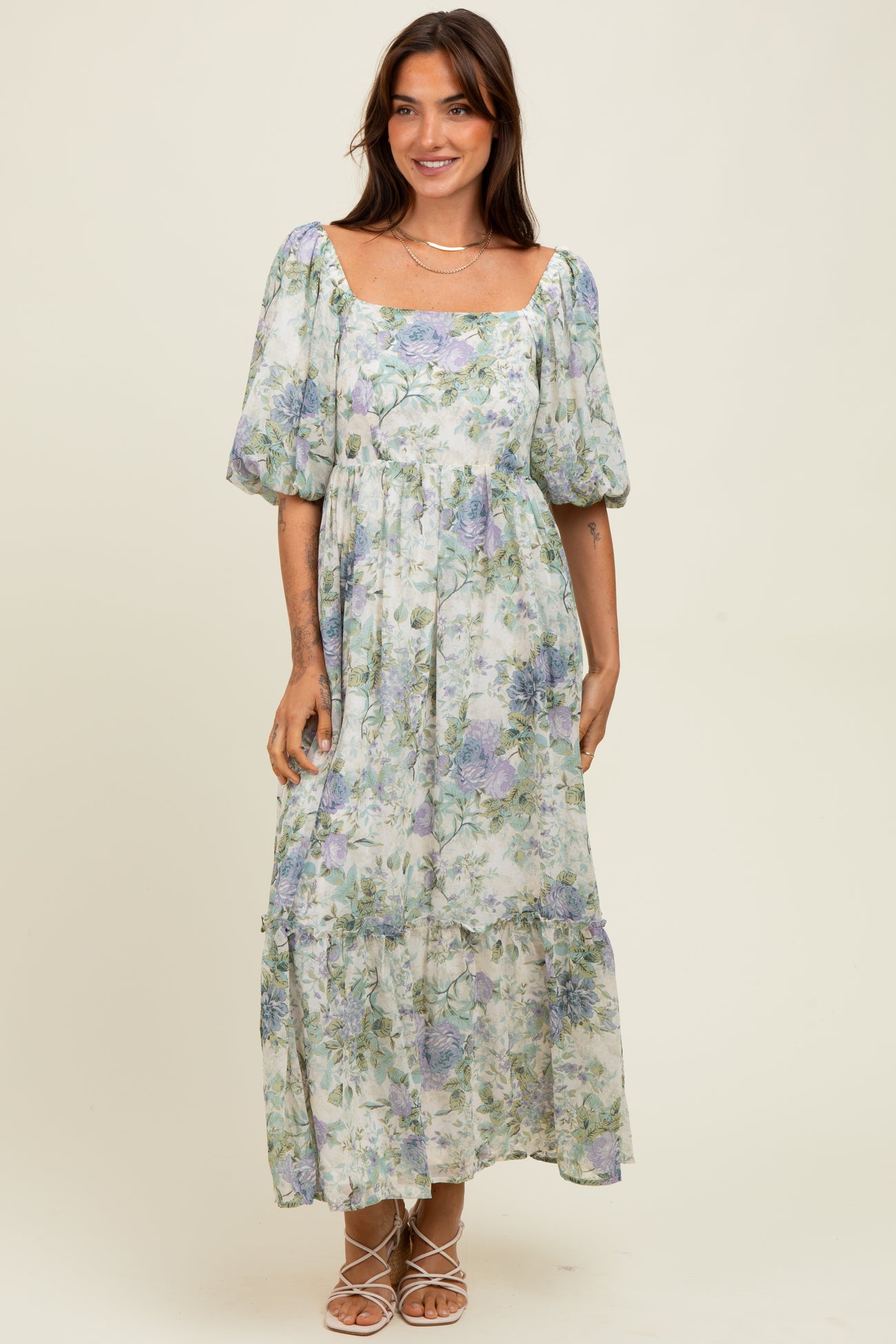 woman wearing a floral maxi dress with puff sleeves and a square neckline
