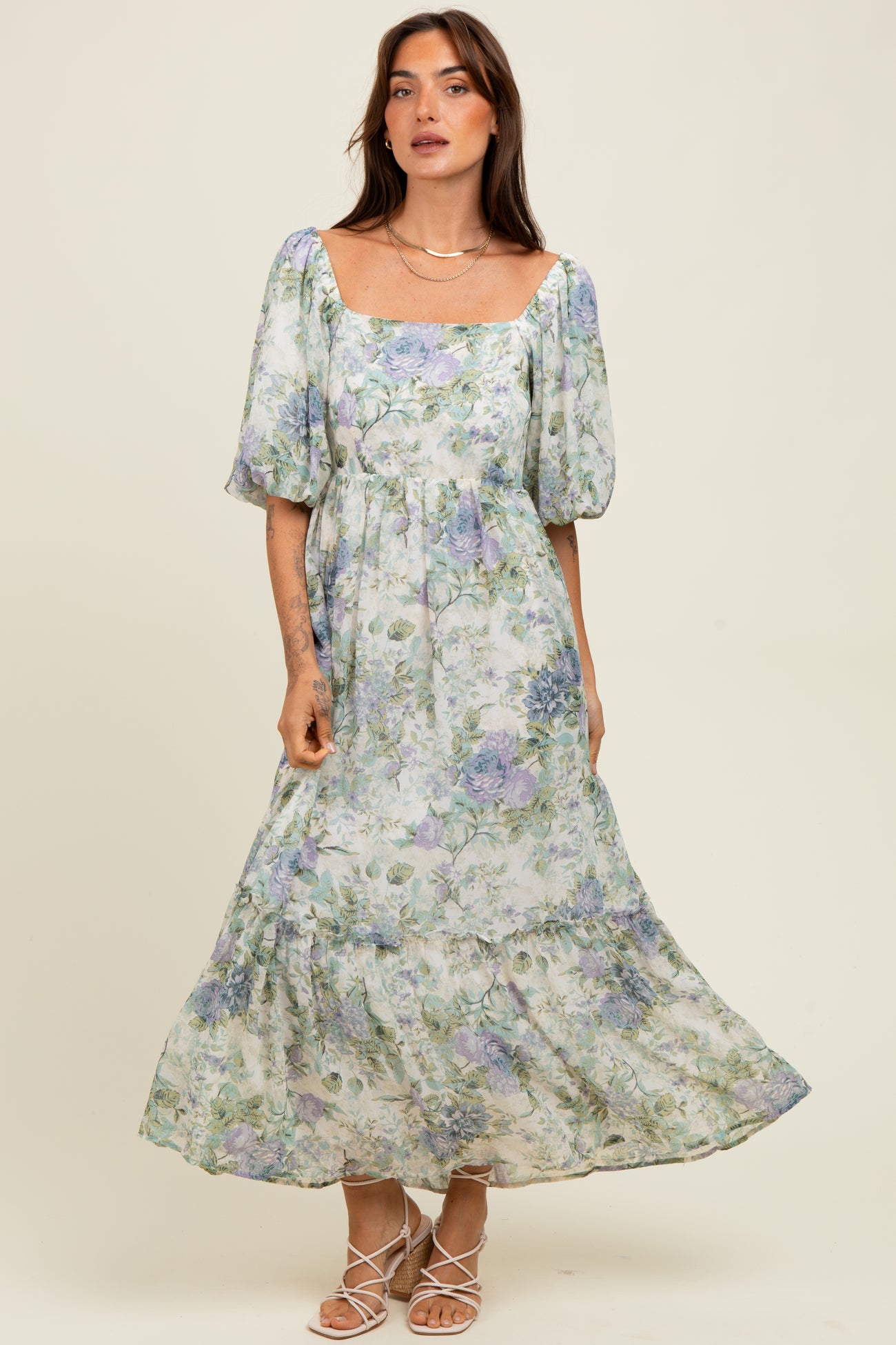 woman wearing a floral print maxi dress with puff sleeves and a square neckline