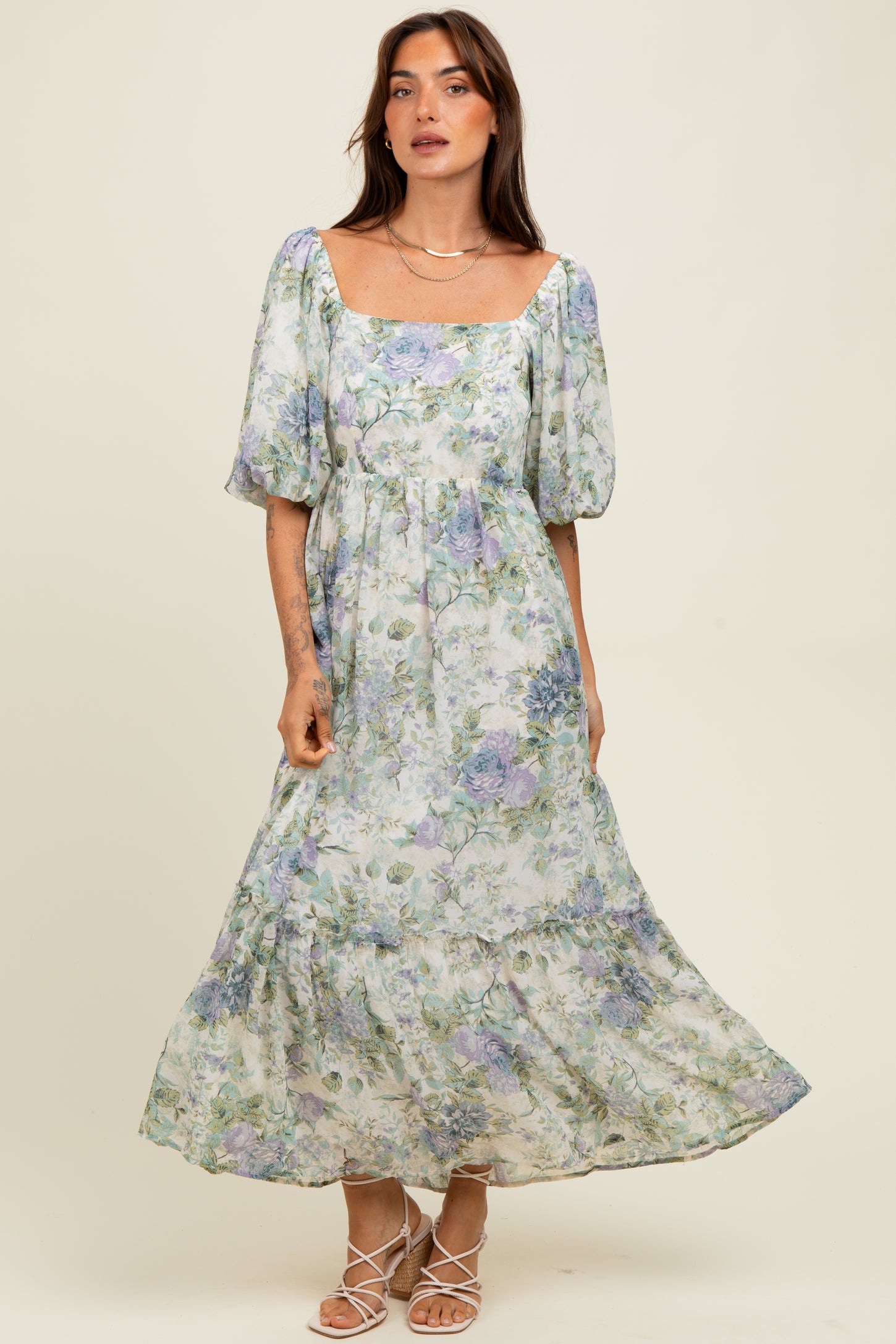 woman wearing a floral print maxi dress with puff sleeves and a square neckline