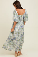 woman wearing a floral maxi dress with puff sleeves and a smocked back, posing with her back to the camera