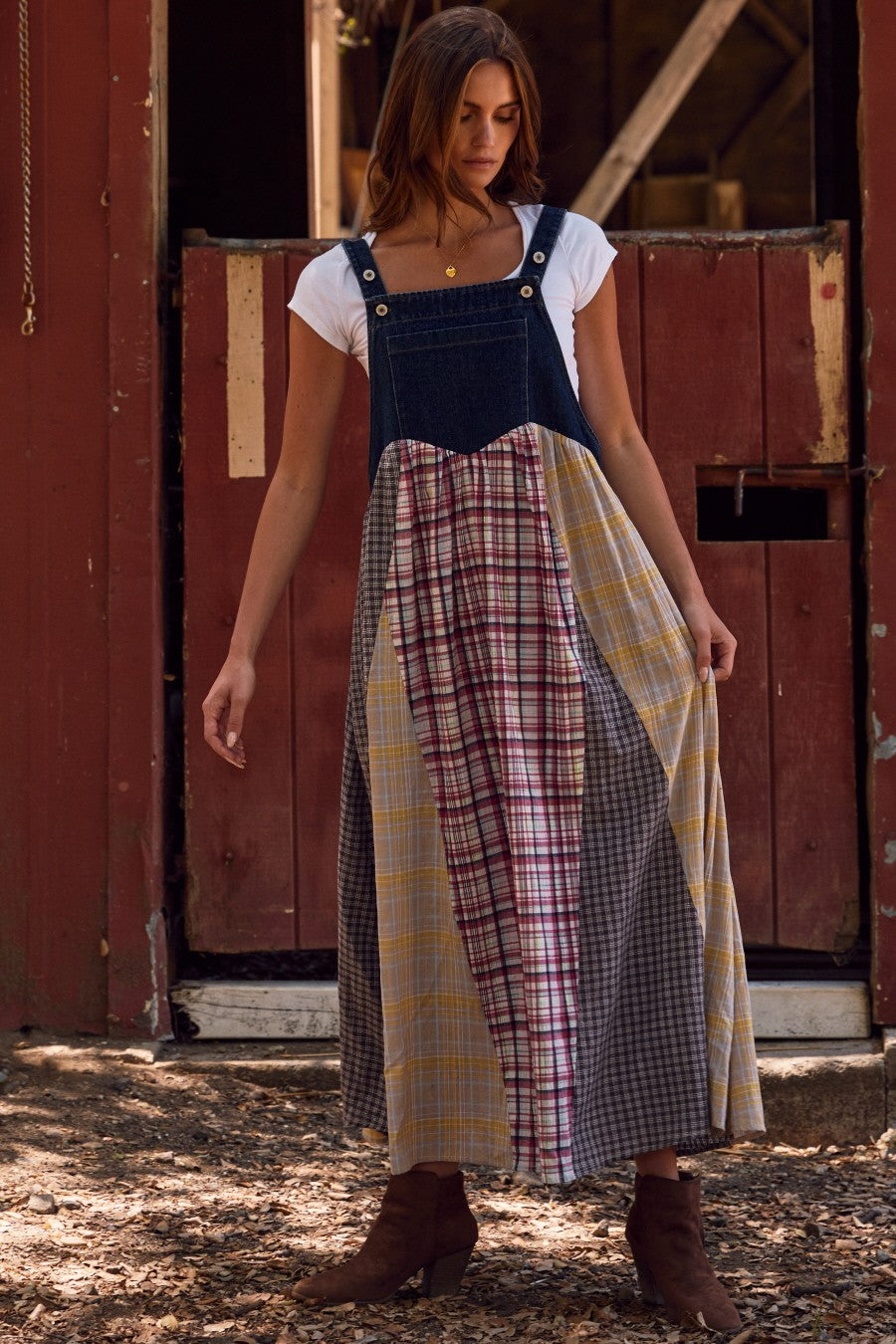 woman wearing a patchwork maxi dress with a denim top and plaid patterns in yellow, gray, and red