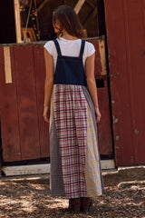 woman wearing a denim strap dress with a patchwork design in plaid and check patterns