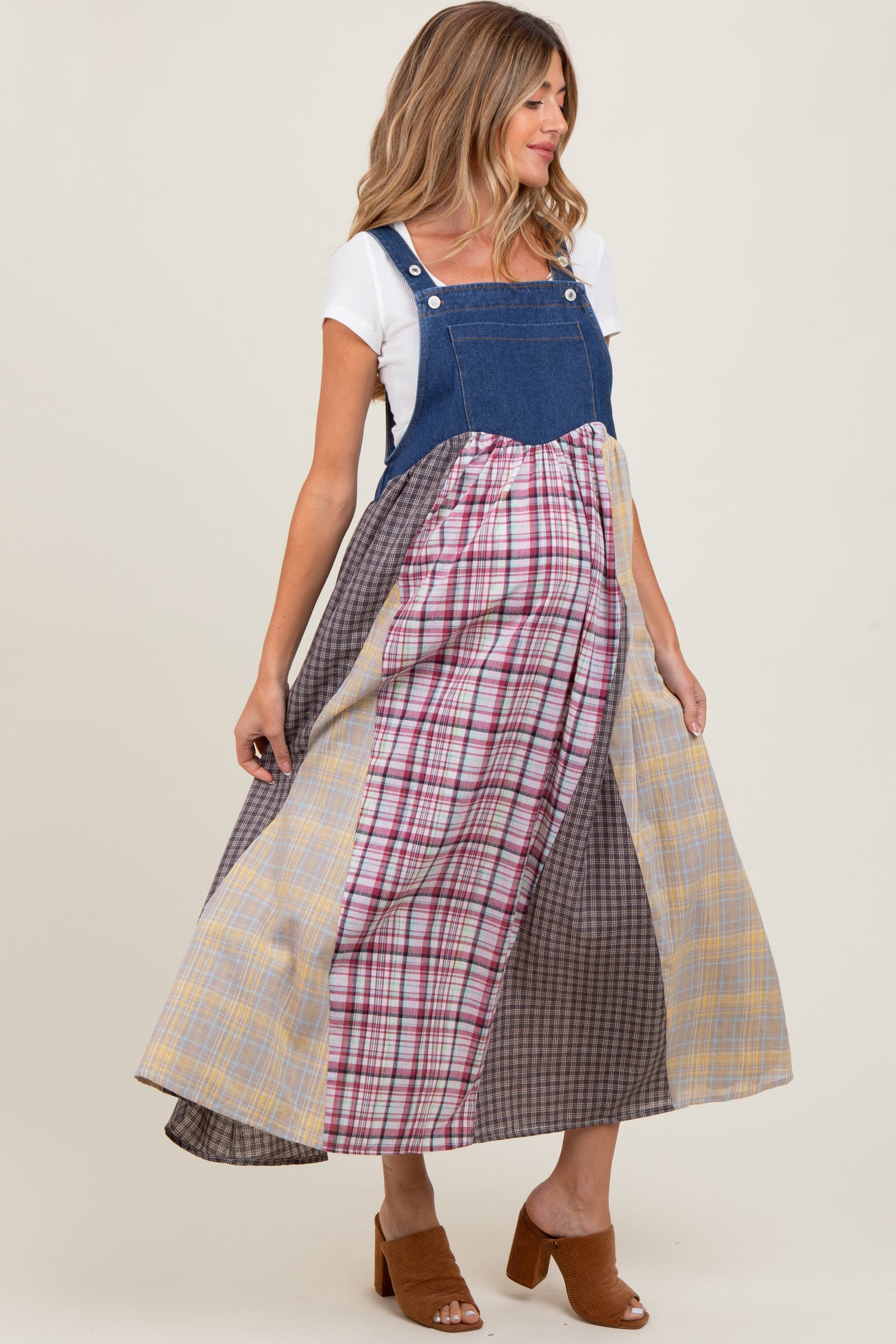 woman wearing a maternity denim maxi dress with multi-colored plaid panels and side pockets