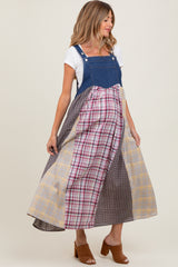 woman wearing a maternity denim maxi dress with multi-colored plaid panels and side pockets