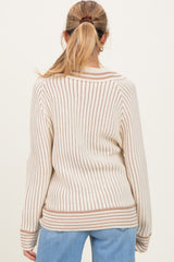 woman wearing a cream and brown striped maternity sweater, showing the back view