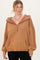woman wearing a tan oversized pullover hoodie with a half zip and front pocket