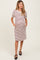 woman wearing a striped maternity dress with short puff sleeves and pockets, showcasing her baby bump
