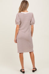woman wearing a striped maternity dress with short puff sleeves and a fitted silhouette, showing a baby bump