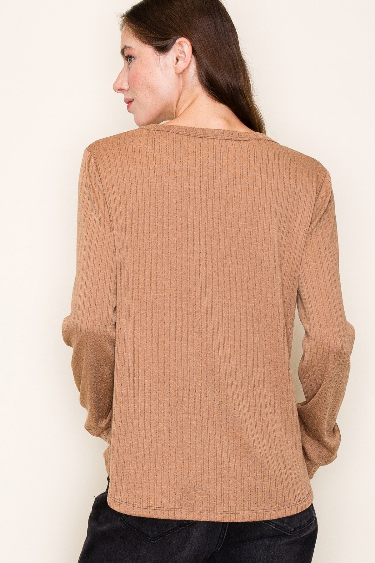 woman wearing a brown ribbed long sleeve top, viewed from the back