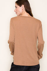 woman wearing a brown ribbed long sleeve top, viewed from the back