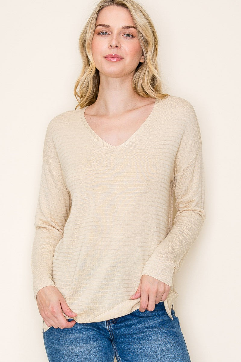 woman wearing a beige striped long sleeve v-neck top with a relaxed fit