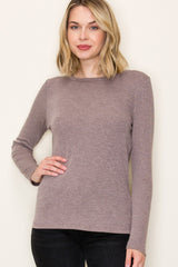 woman wearing a taupe long sleeve ribbed top with a round neckline and a relaxed fit