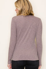 woman wearing a mauve long sleeve top with a ribbed texture, shown from the back
