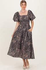 woman wearing a dark floral print maxi dress with puff sleeves and pockets