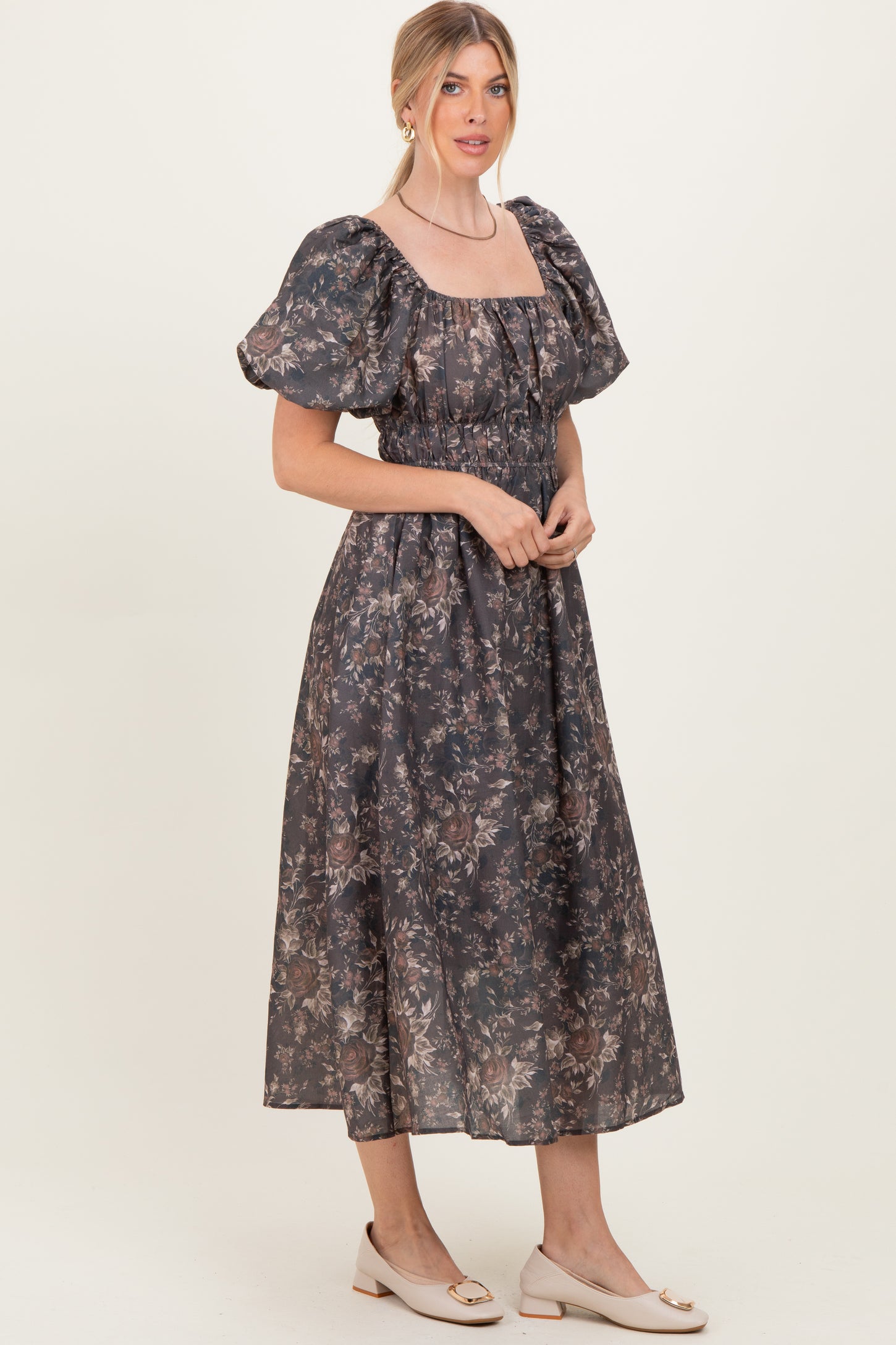 woman wearing a dark floral print maxi dress with puff sleeves and a square neckline