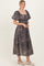 woman wearing a dark floral print maxi dress with puff sleeves and a square neckline